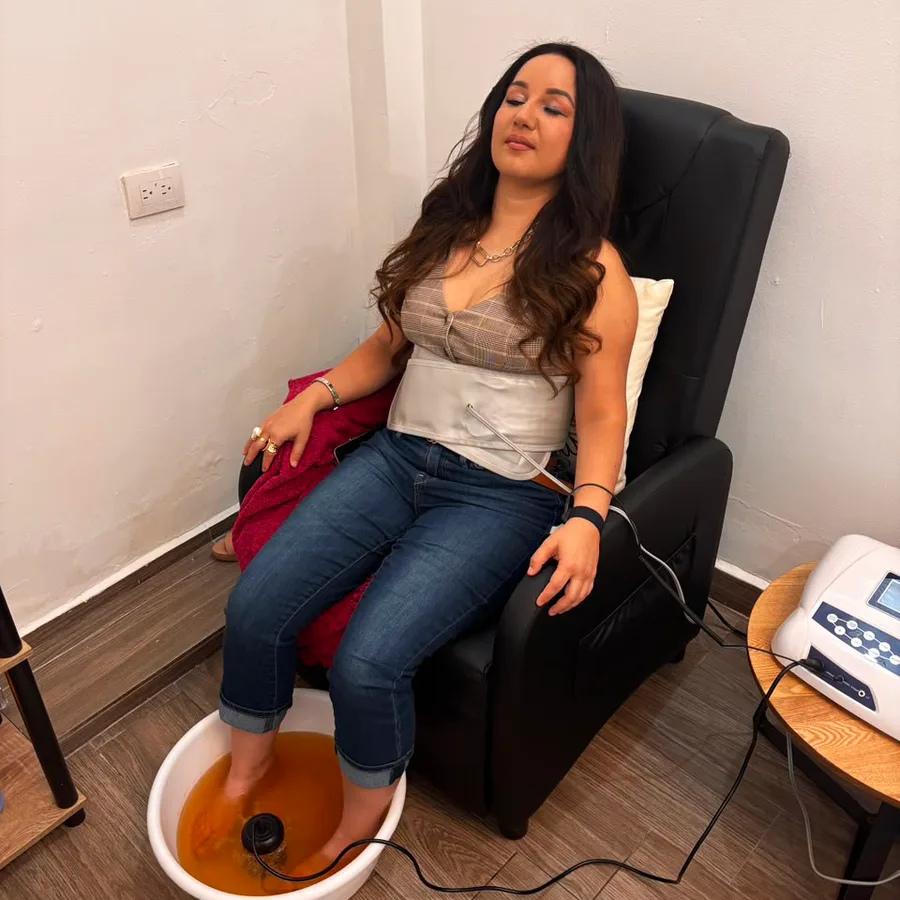 Paciente recostada en el sillón mientras recibe la sesión de pediluvio