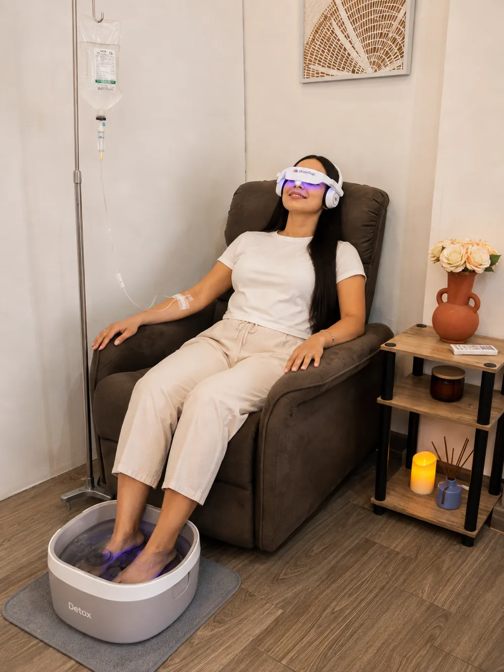Paciente en sesión combinada de sueroterapia intravenosa, BrainTap y detox iónico en una sala de Biocure